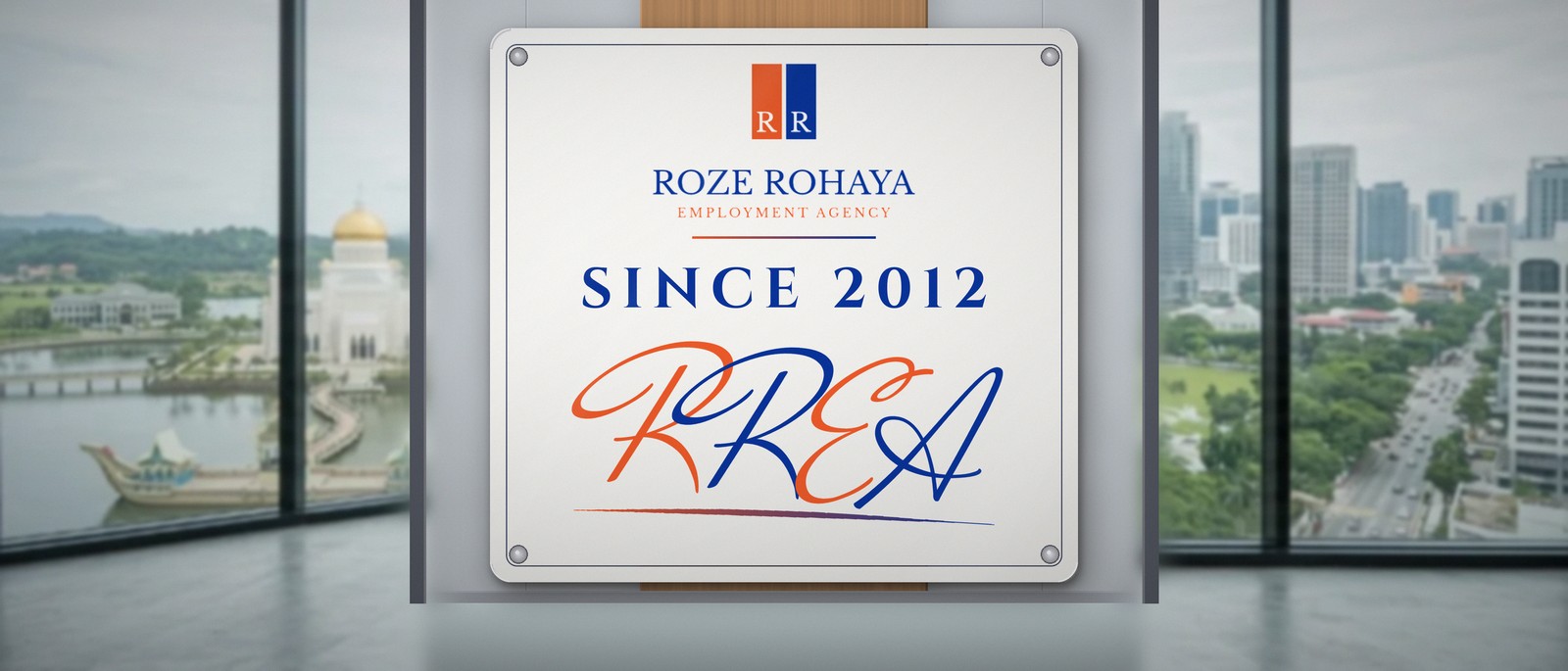 A large wall plaque in the RREA office: the Roze Rohaya logo, Since 2012, and the RREA signature, with the Brunei skyline behind