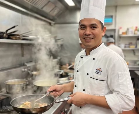 A chef preparing food in a professional kitchen